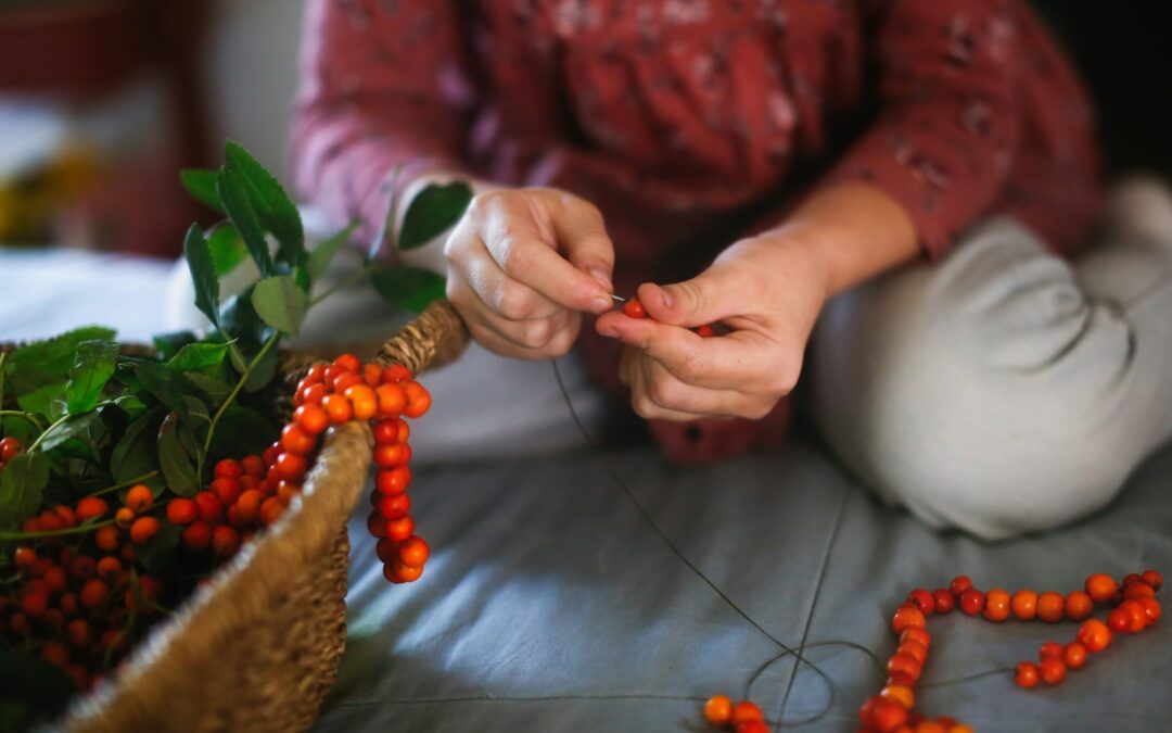 The child makes rowan beads from rowan berries, crafts and handicrafts